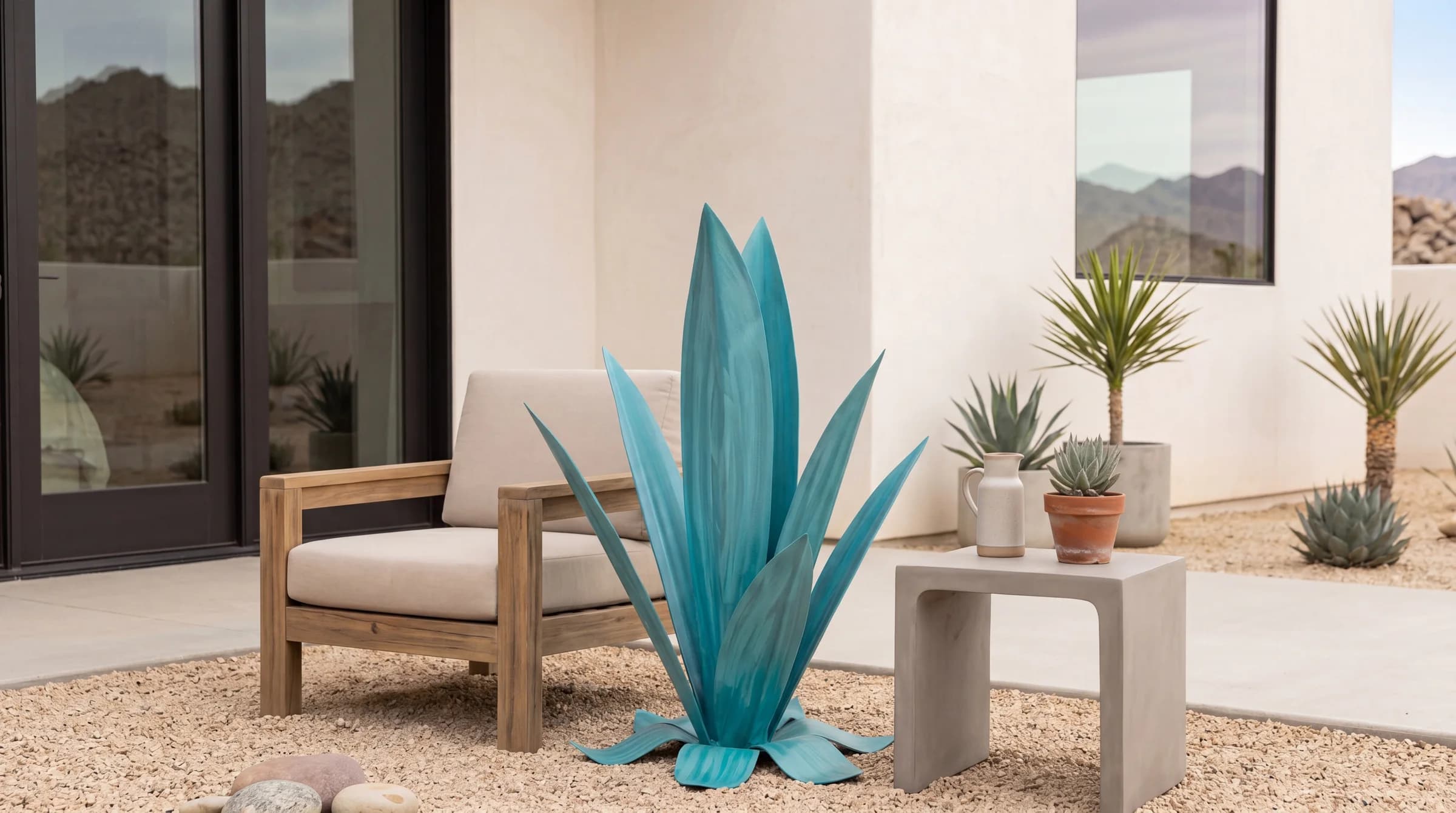 Turquoise steel Agave beside a lounge chair in a sunlit desert courtyard