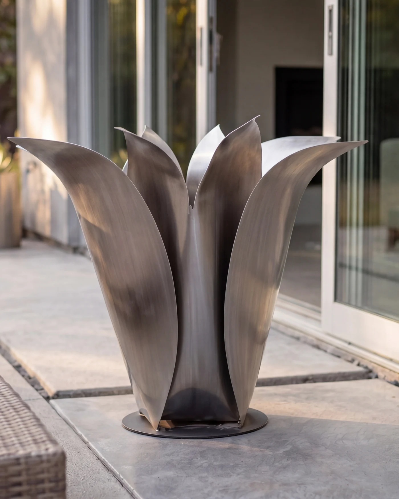 Silver Blossom sculpture on a stone terrace in soft afternoon light