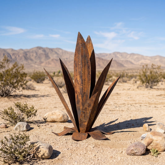 Metal sculpture resembling a desert plant in a desert landscape with mountains in the background
