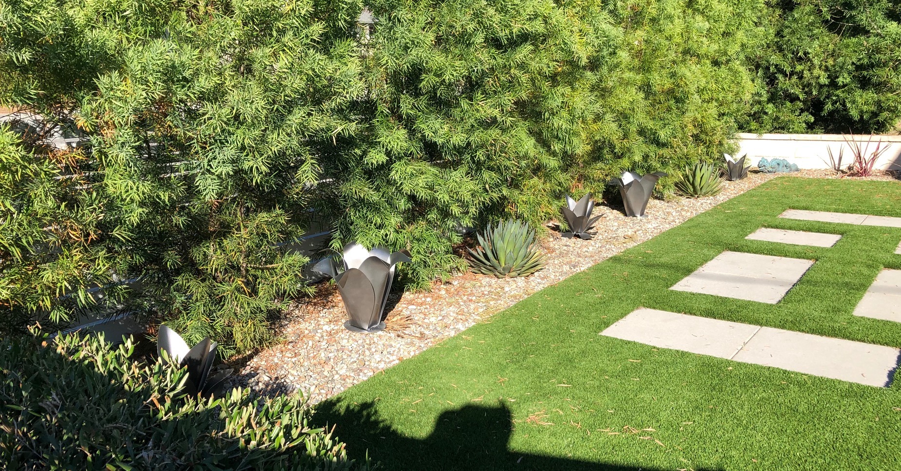 View from the opposite end of the path showing steel flowers among living plants