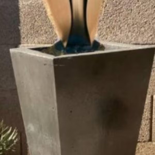 Close-up of a steel sculpture base inside a square planter