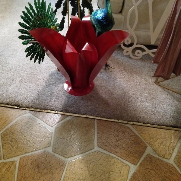 Red steel Blossom photographed indoors beside a tiled floor